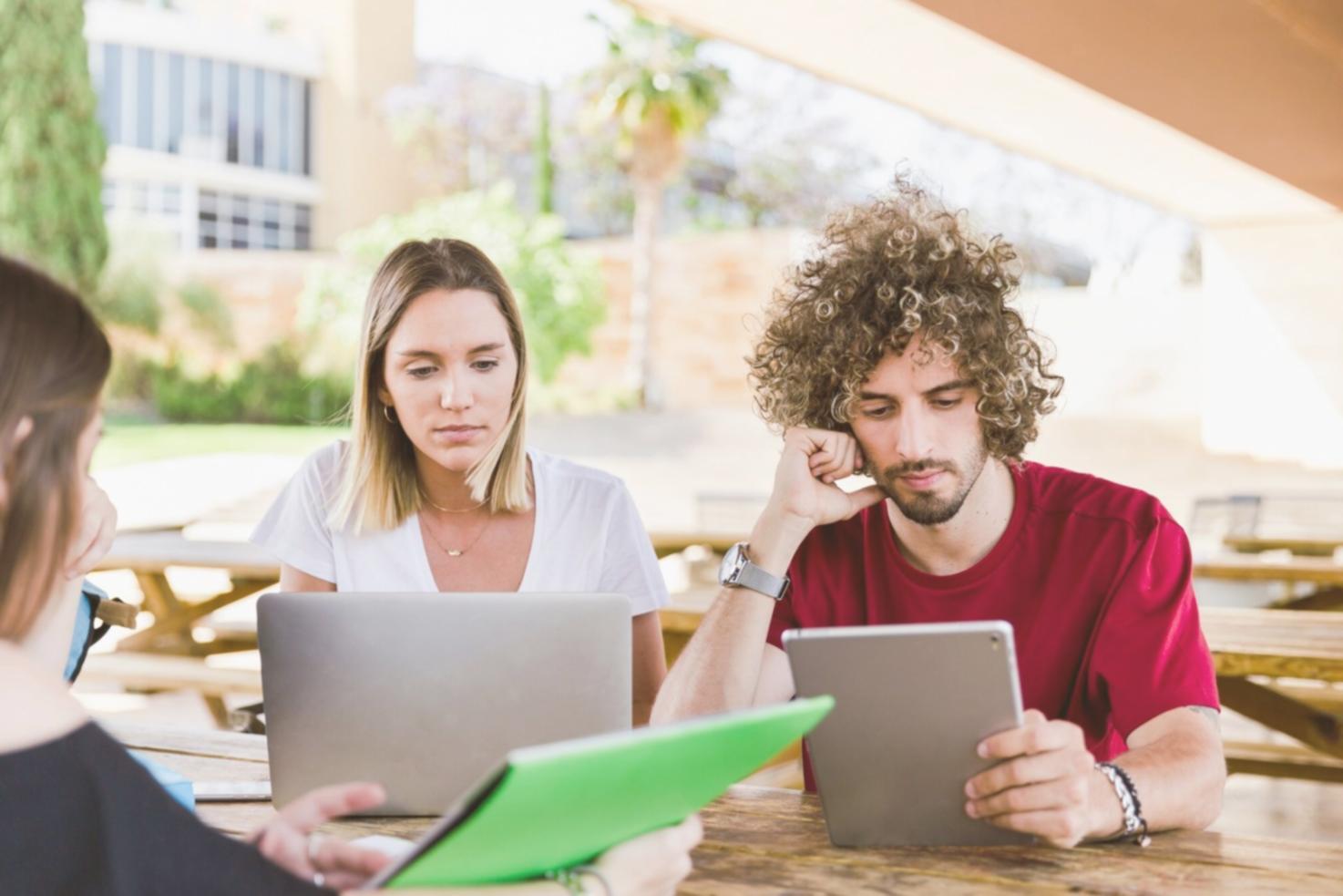 Financial analyst reviewing complex data visualizations on multiple monitors